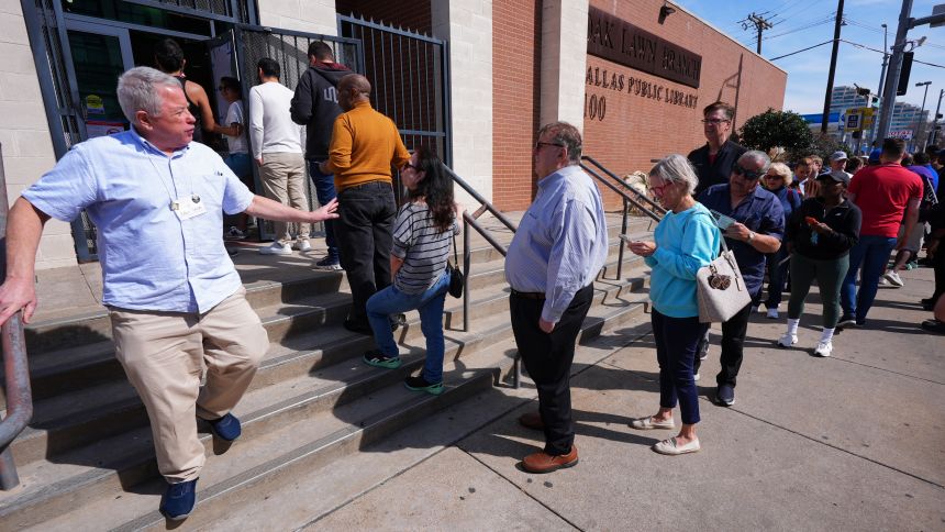 Voters stand in line to vote early for the primary election, in Dallas, Tuesday, February 17.