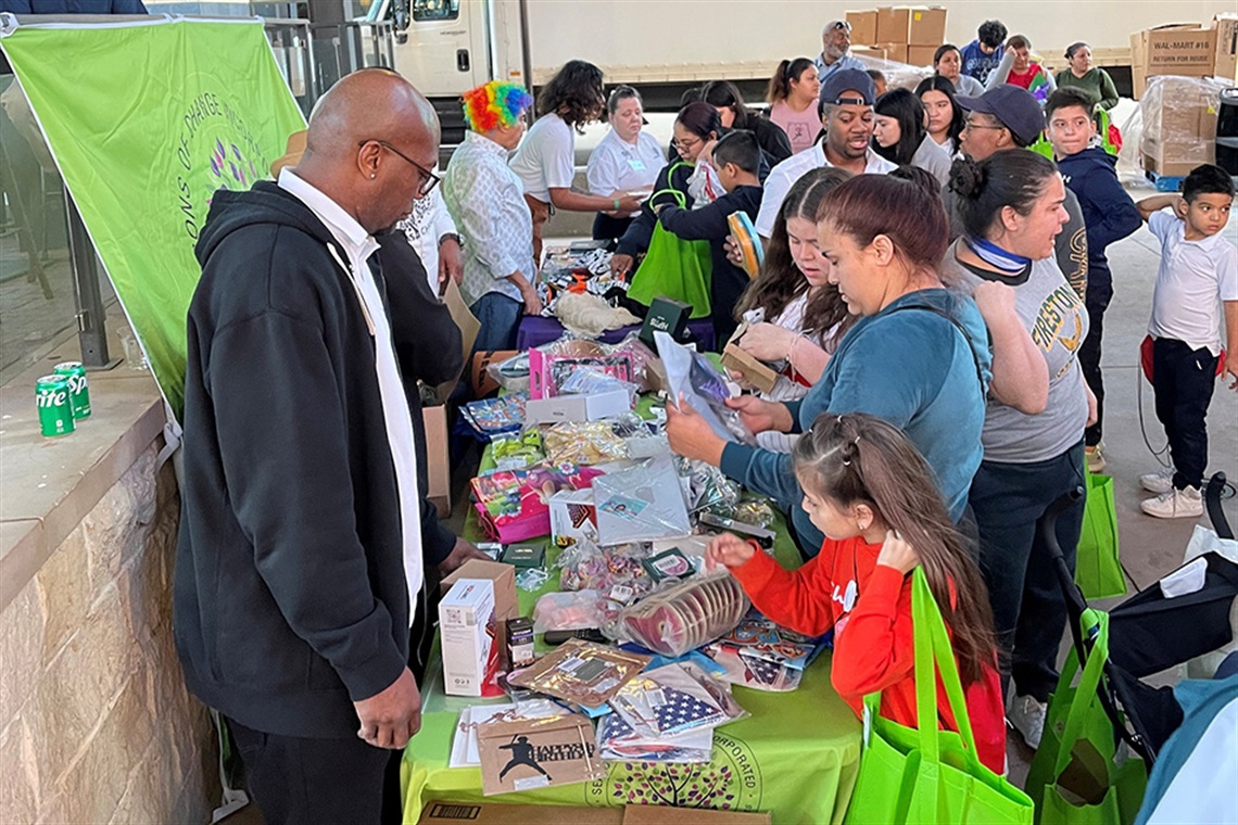 People standing at a booth receiving swag and resources