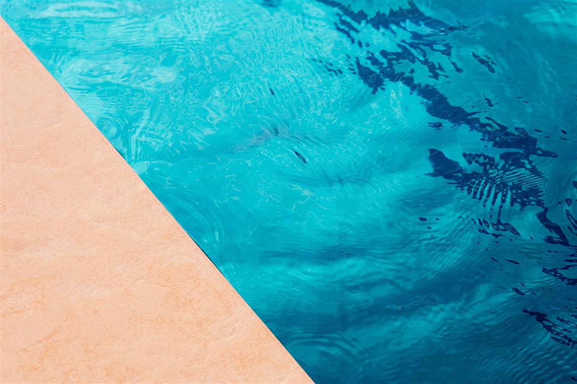Swimming pool top view background with sunlight reflection, shadow on floor and blue water waves.