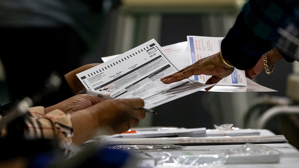 A voter receives a ballot on April 1, 2025, in the suburban Cook County Consolidated Election at Yates Elementary School in Matteson, Illinois. 