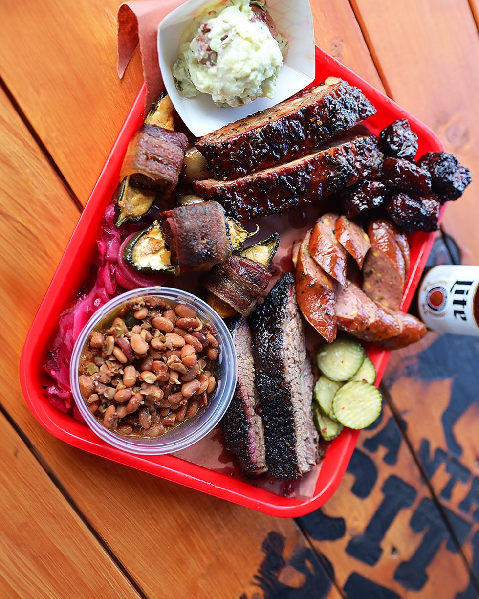 barbecue platter with various meats and sides served in a red tray