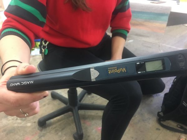 A woman seated and holding a portable image scanner