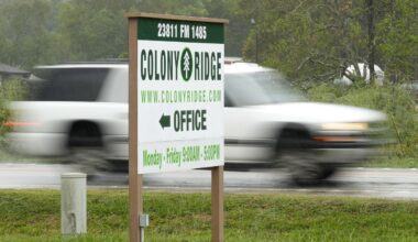 A vehicle passes the Colony Ridge office sign Tuesday, Oct. 3, 2023, in Cleveland, Texas. (AP Photo/David J. Phillip)