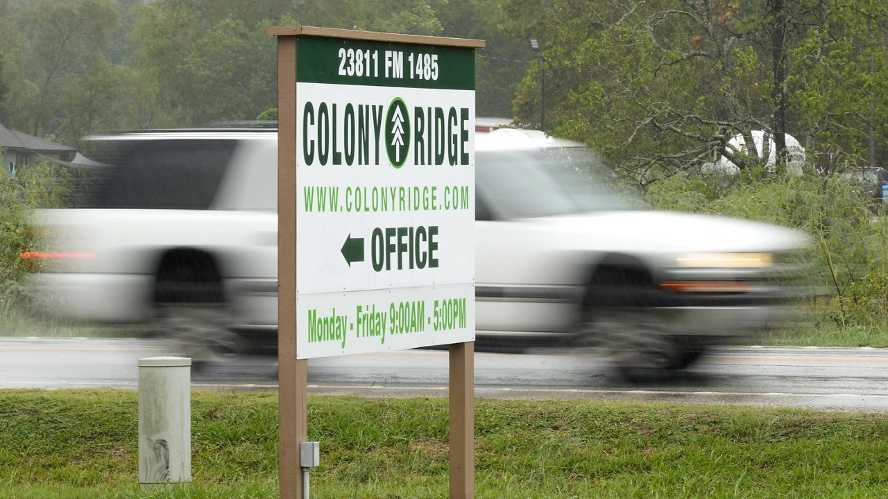 A vehicle passes the Colony Ridge office sign Tuesday, Oct. 3, 2023, in Cleveland, Texas. (AP Photo/David J. Phillip)