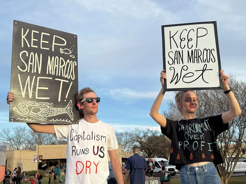 Scott Murdoch and Shelby Young protest outside San Marcos City Hall as residents oppose a proposed $1.5 billion data center on February 17, 2026. Council members later voted 5-2 to deny the zoning changes needed for the project to move forward. (Nicholas Hernandez/MySA)