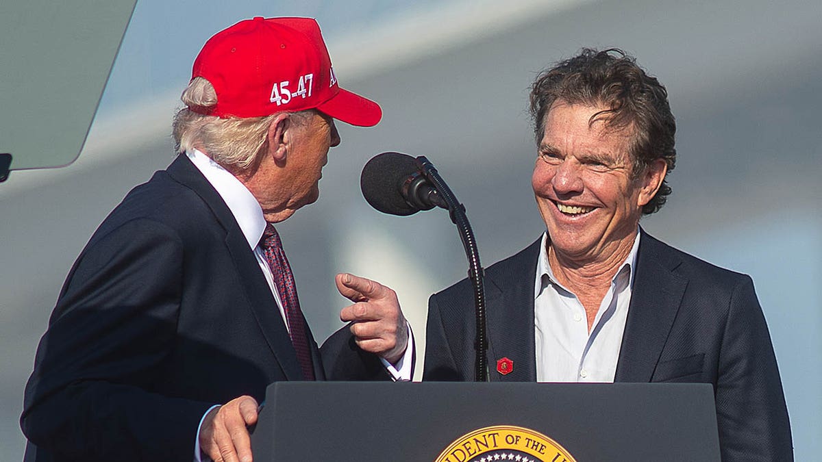 President Donald Trump speaks to Dennis Quaid on stage at a rally in Corpus Christi, Texas.