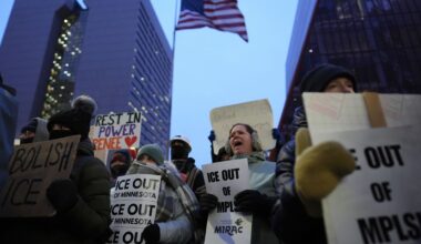 Demonstrators hold signs during a protest outside the office of Sen. Amy Klobuchar, D-Minn., on Monday in Minneapolis. (AP Photo/Adam Gray)