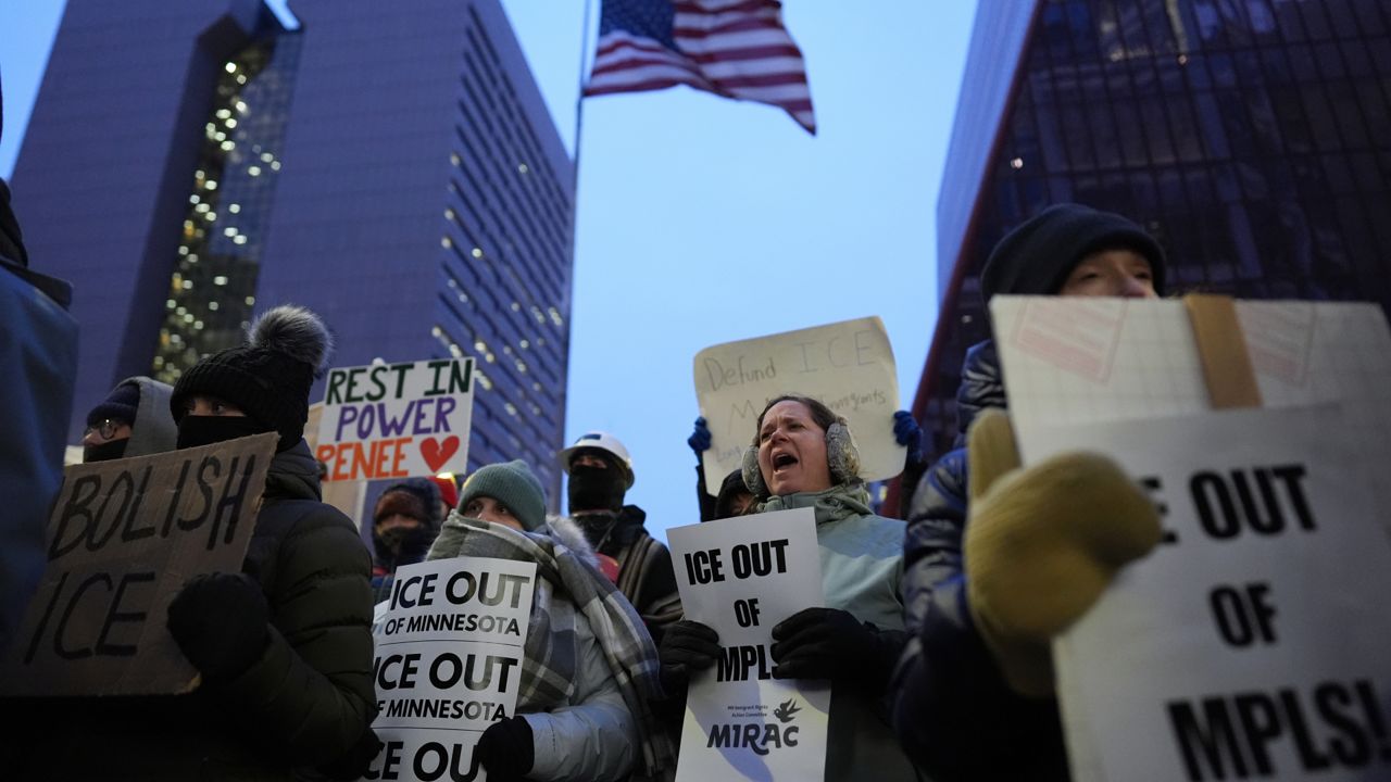 Demonstrators hold signs during a protest outside the office of Sen. Amy Klobuchar, D-Minn., on Monday in Minneapolis. (AP Photo/Adam Gray)