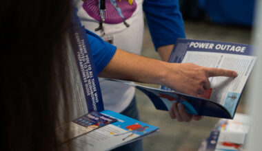 photo of a hand pointing to preparedness information regarding power outages in a booklet