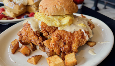 A huge chicken and biscuit sandwich on a plate.