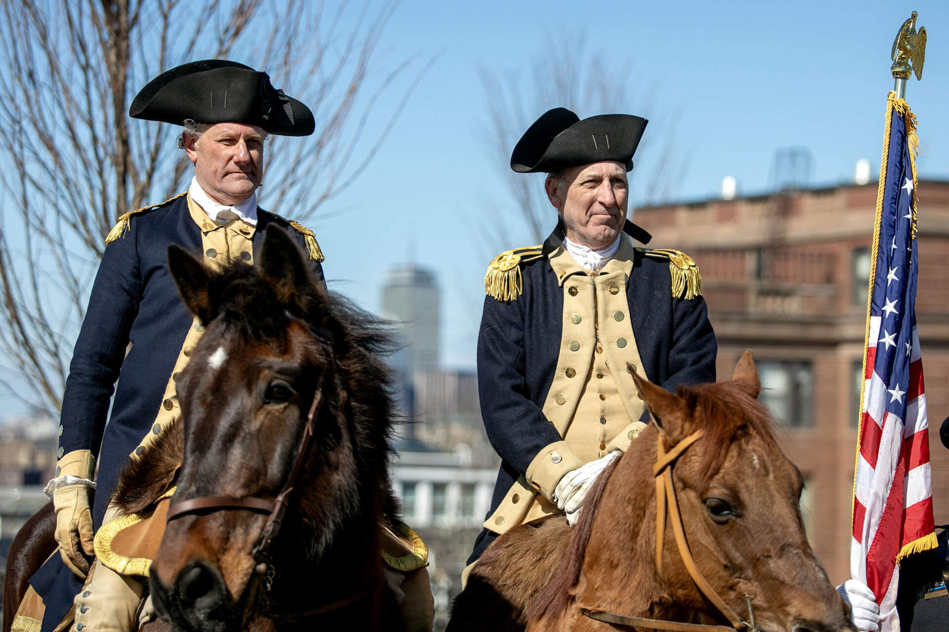 Reenactors on horses stand on Dorchester Heights at a gathering to commemorate the 250th Anniversary of Evacuation Day. (Robin Lubbock/WBUR)