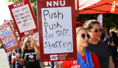 Nurse on picket line holds sign "Push Push for Safe Staffing"