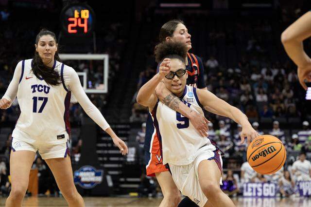TCU guard Olivia Miles (5) is clotheslined by Virginia guard Romi Levy (23) as she drives to the basket in the first half of a Sweet 16 game in the NCAA Tournament on Saturday at Golden 1 Center in Sacramento, Calif.