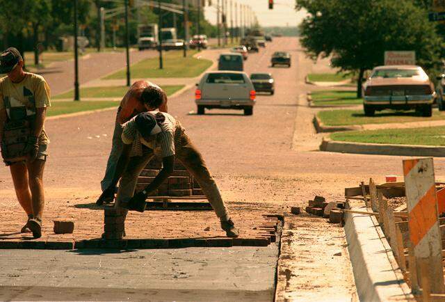 July 19, 1988: Workers endure Texas heat while laying bricks on Camp Bowie Boulevard. The project involved removing bricks between Hillcrest and Hulen streets, redoing the foundation and returning the restored brick to the boulevard. The laborers jokingly told a reporter they called themselves the “stars of the boulevard,” “working-class heroes” and “sons of the square-winged angels.”