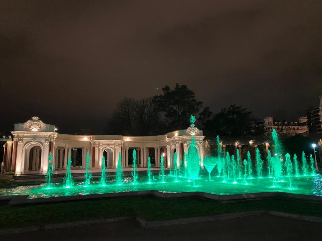 Doña Casilda Iturrizar Park in Bilbao, Spain. The fountains are glowing teal for Long COVID Awareness Day.