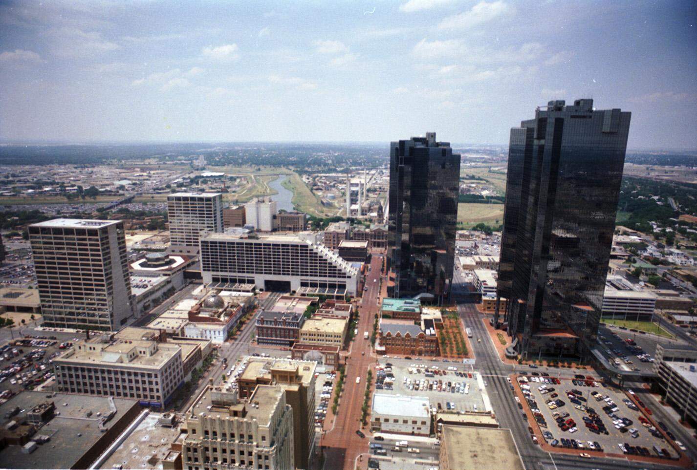 May 1988: Downtown Fort Worth looking north up Main Street. The pedestrian plaza that would later become the center of Sundance Square is a parking lot.