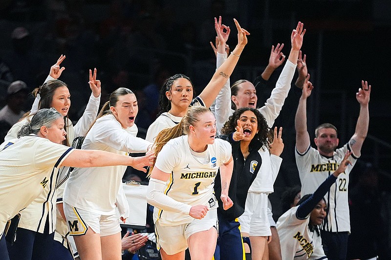 Michigan players celebrate a 3-pointer by Olivia Olson (1) during an NCAA tournament Sweet 16 game against Louisville on Saturday in Fort Worth, Texas. (AP Photo/LM Otero)