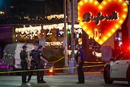 Austin police officers work at the scene on West Sixth Street after a shooting outside...