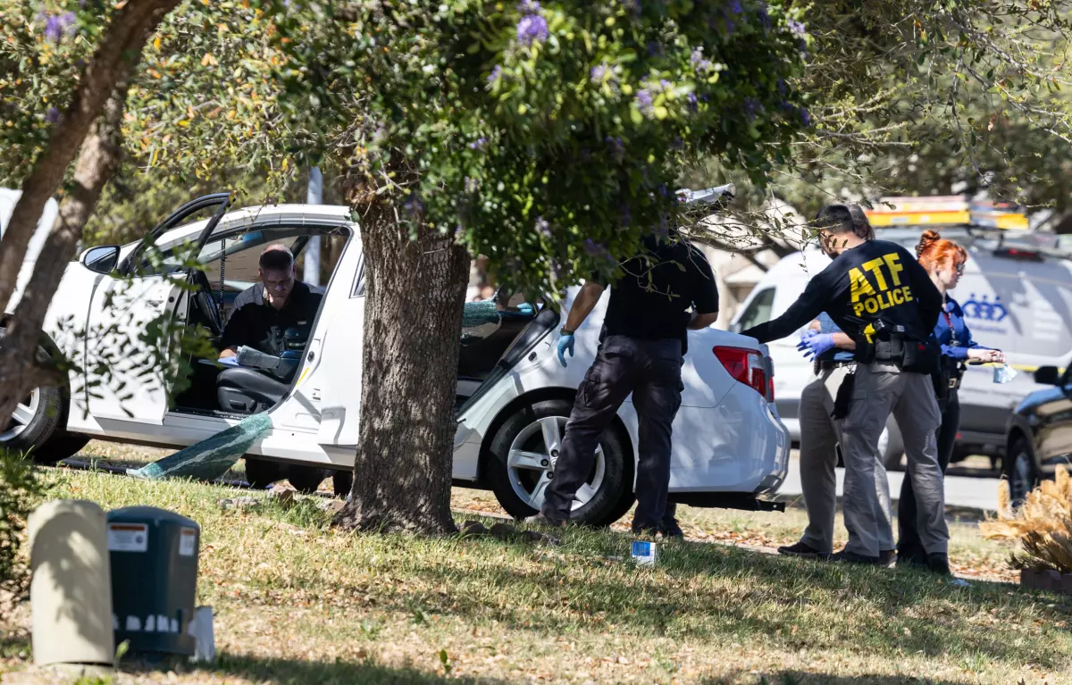 Law enforcement officers search a car at a residence in Pflugerville connected to the suspected shooter.