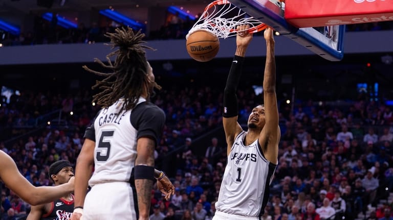 San Antonio Spurs' Victor Wembanyama, right, dunks the ball as...