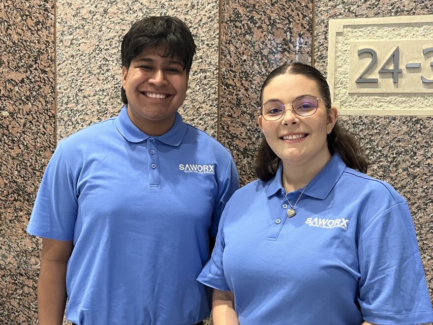 A 21-year-old man and a 20-year-old woman in light-blue polo shirts smile for a photo.