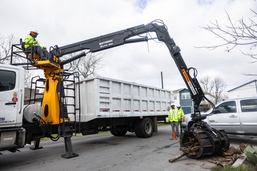 A crane operator uses the device to pick up wood outside a home. 