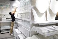 Employee Chris Chow adjusts price signs in the new IKEA store located at the Shops at Park...