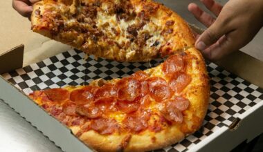 Kylie Painter, a pizzaiolo at Authentic New York Pizza, slices up a chicken Alfredo pizza on Feb. 8, 2023.