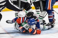 Dallas Stars' Lian Bichsel (6) and Edmonton Oilers' Adam Henrique (19) rough it up during...