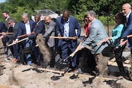 Dignitaries turn shovels filled with dirt at a groundbreaking ceremony to launch the...