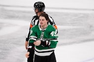 Dallas Stars center Justin Hryckowian is escorted to the penalty box for fighting in the...