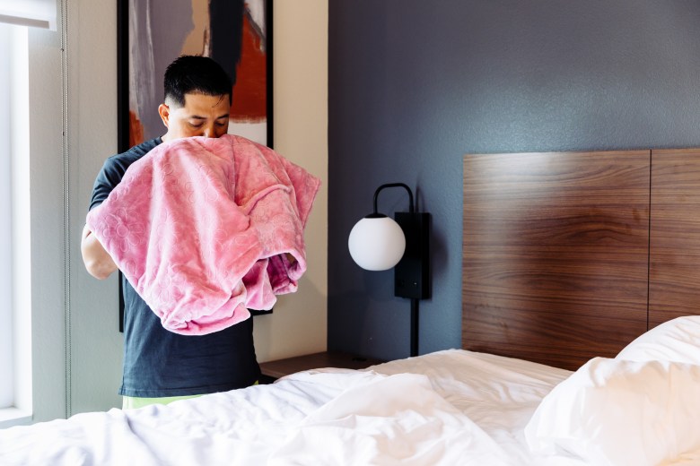 Juan Rodriguez smells a blanket that belonged to his fiancée, Johanny Carolina Lacruz Villalobos, inside his hotel room at Everhome Suites in San Antonio. Rodriguez said Lacruz Villalobos, a Venezuelan woman who entered the United States through the CBP One app, was detained by U.S. Immigration and Customs Enforcement (ICE) while the couple was traveling to San Antonio and is currently being held at a detention facility in Raymondville.