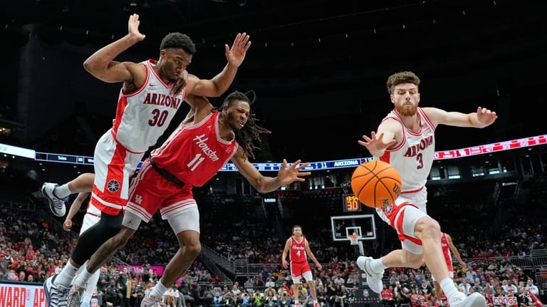 Houston's Joseph Tugler (11) chases a loose ball between Arizona's...