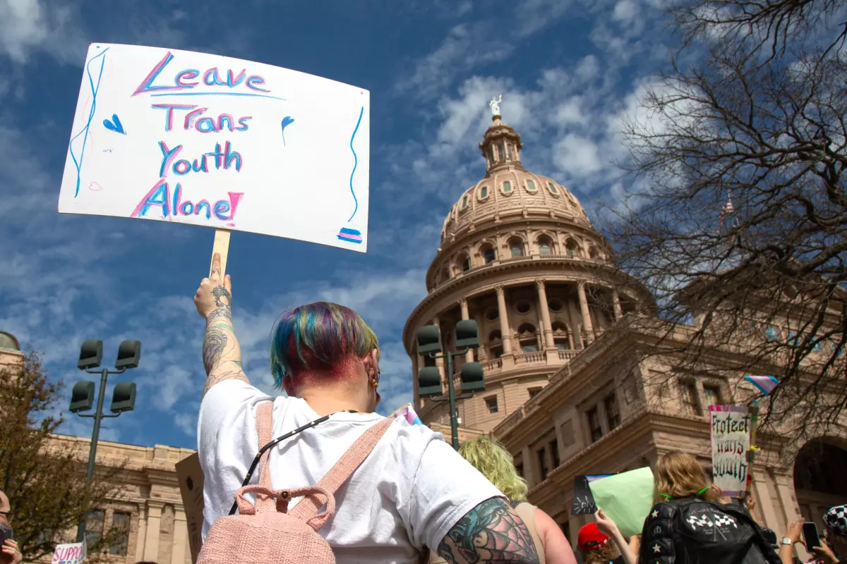 Demonstrators hold signs in support of transgender youth and rights at the Rally for Trans Youth at the Texas State Capitol in March 2022.