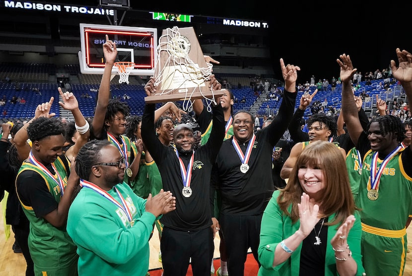 Dallas Madison head coach Gerald Smith raises the championship trophy  after a victory over...