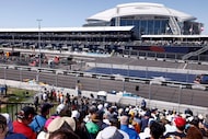 Fans watch as drivers race towards turn one near AT&T Stadium during the IndyCar Grand Prix...