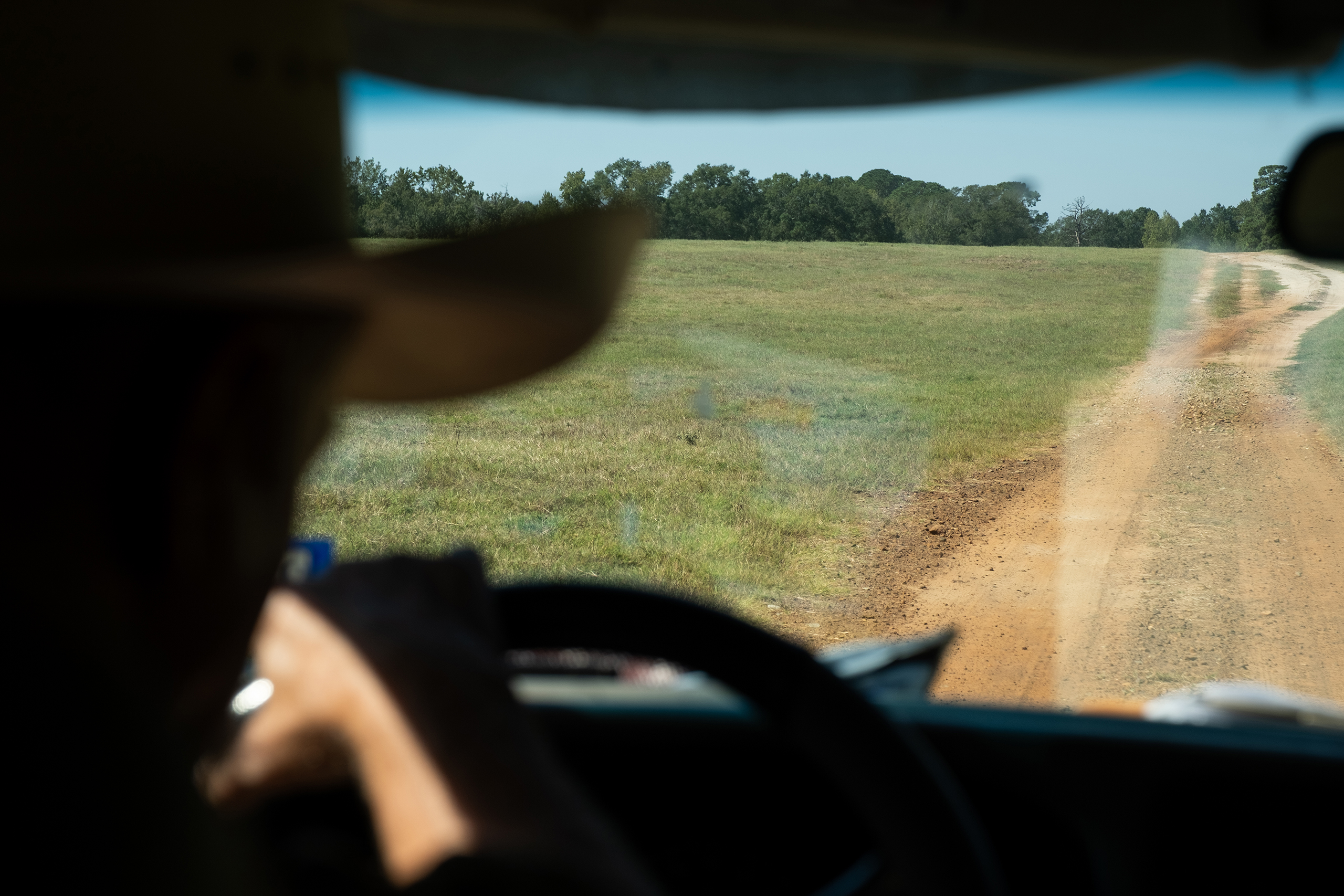 Bob Sanders steers his pickup along a dirt road on his East Texas ranch.