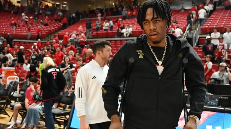 Texas Tech forward JT Toppin uses crutches to walk after...