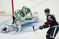 Colorado Avalanche center Nathan MacKinnon, right, has his shot stopped by Dallas Stars...