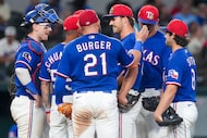 Texas Rangers pitcher Carter Baumler (68) gets a pat on the back from first baseman Jake...