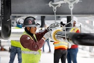 Construction workers build out the rooftop chillers and water lines feeding them atop Dallas...
