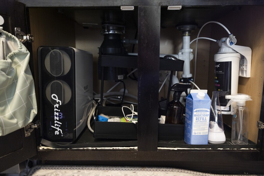 A reverse osmosis water system sits below a kitchen sink.