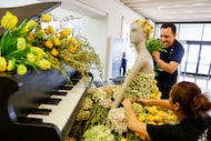 Manuel Lopez (top) and Mami Ogata (bottom), of Bellissimi Fiori, place flowers on a...
