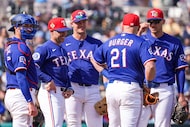 Texas Rangers manager Skip Schumaker (second from left) talks with (from left) catcher Kyle...