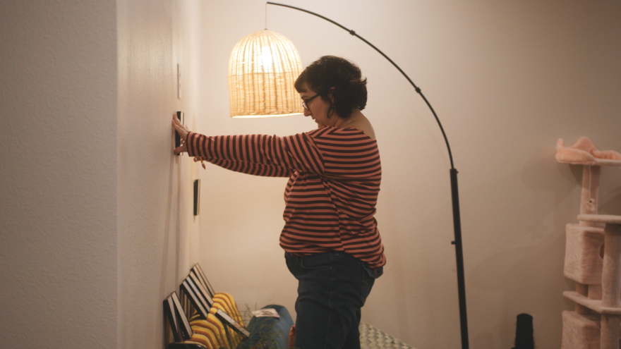 Curator Ryan Semegram installs "Margins of the Midway", a collection of photographs by Alexandra Hulsey exhibited at Semegran's DIY gallery "2 BED 1 BATH"