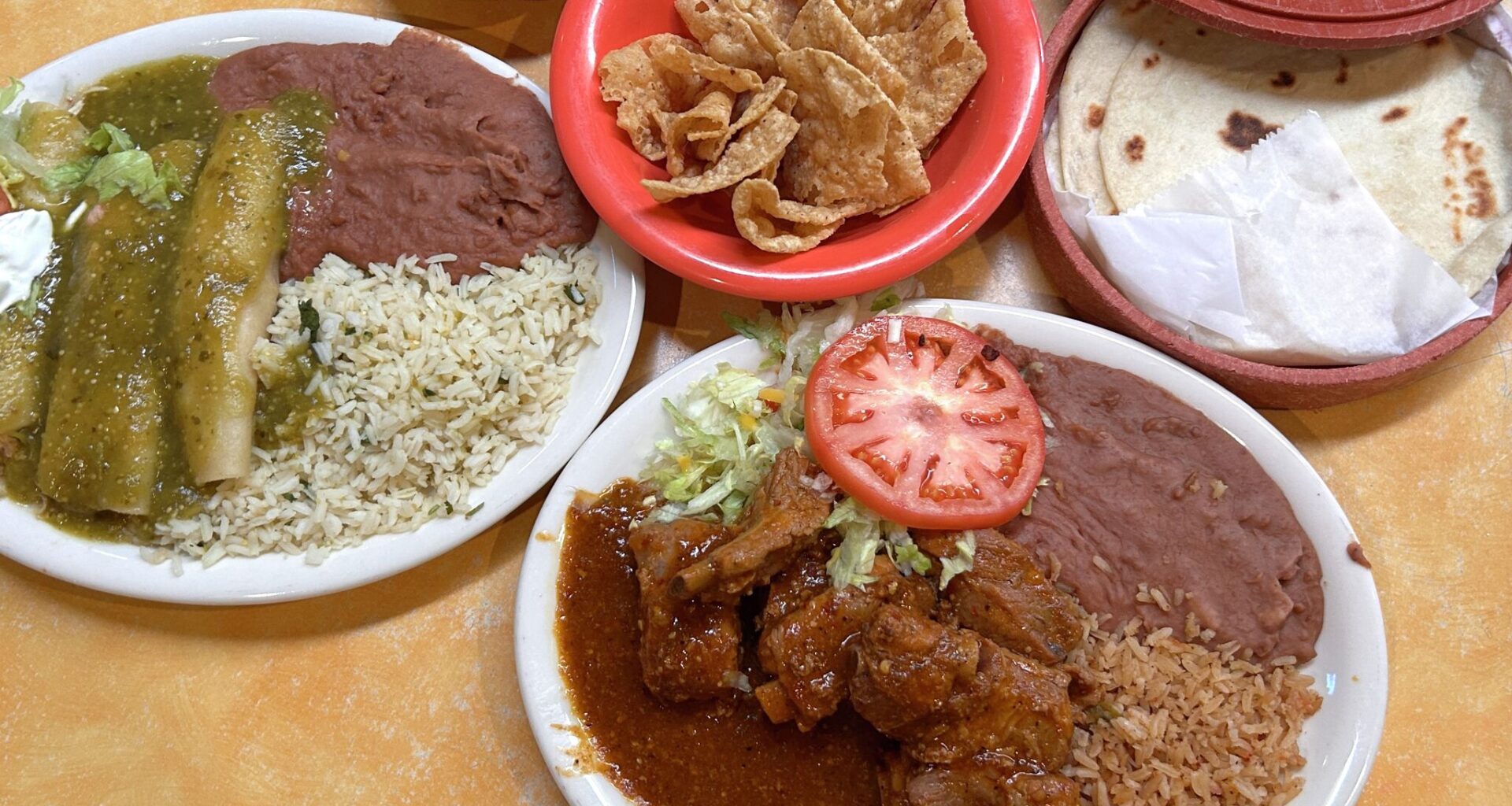 A spread of offerings from Don Pedro, including green chicken enchiladas, costillas de puerco, flour tortillas and chips and salsa. The Mexican restaurant is giving free meals to TSA workers as funding hangs in the balance.