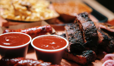 Large servings of barbecue, with pork ribs, sausage, macaroni and cheese, and baked beans.