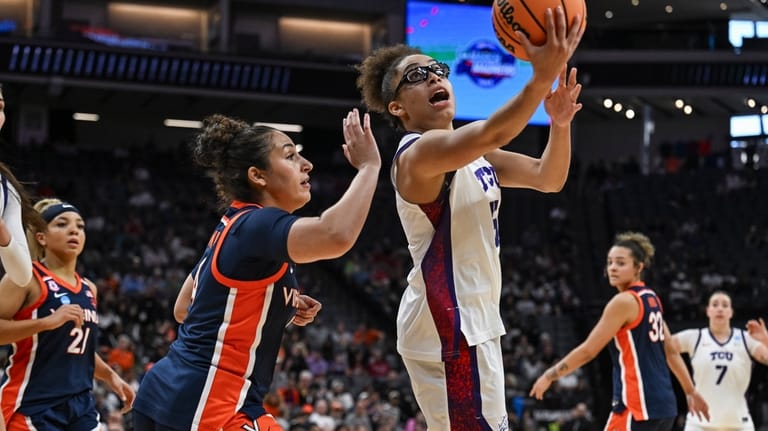 TCU guard Olivia Miles, center, goes for a layup against...