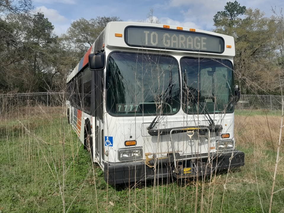 The listing has a photo of a former METRO bus in an open field, with the message sign above the windshield reading "TO GARAGE."