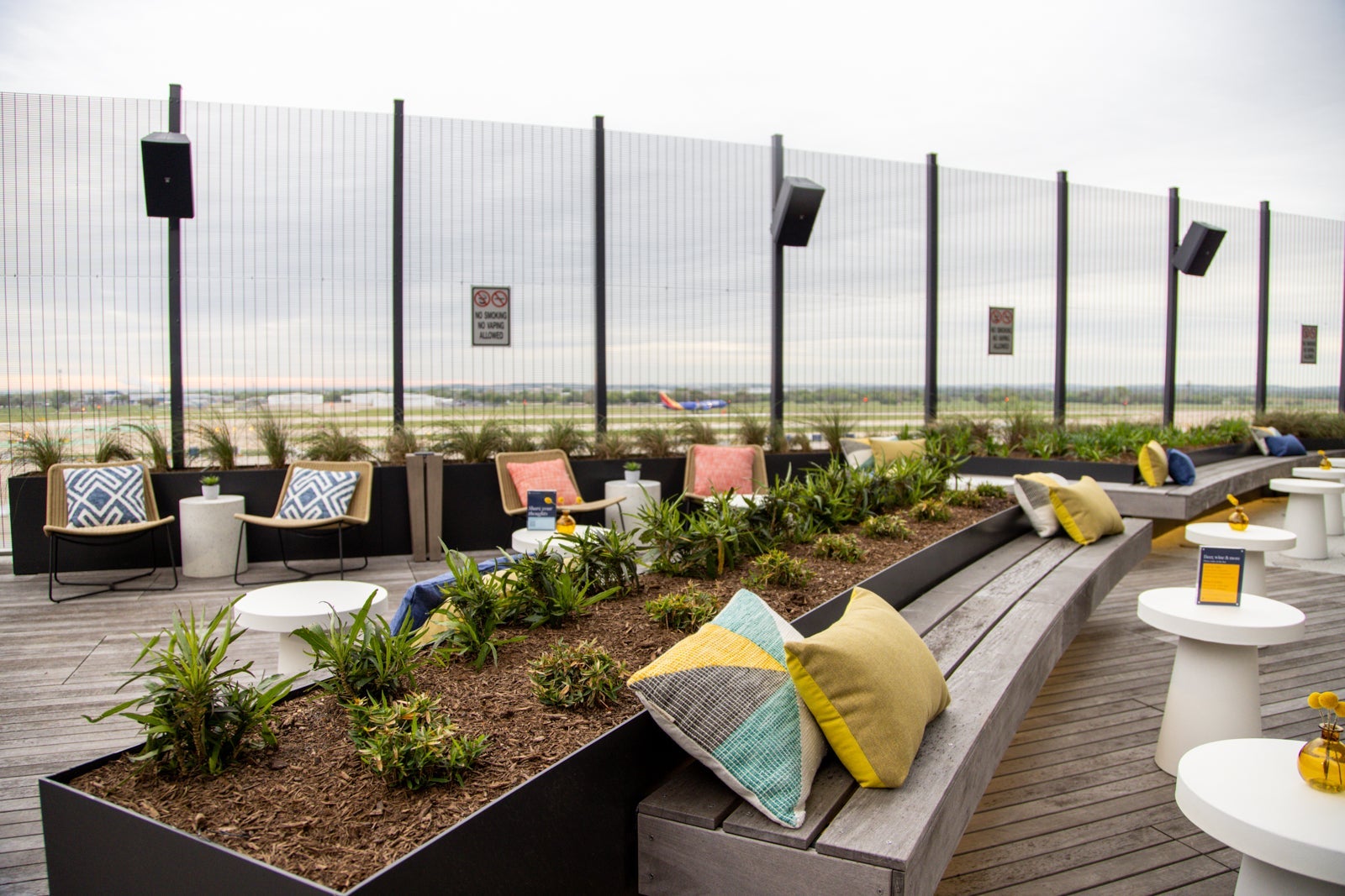 seating options on an outdoor terrace with planes visible in the background